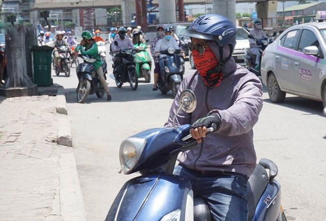 Hà Nội trải qua ngày nắng nóng gắt nhất từ đầu mùa, người dân bịt kín mít khi ra đường